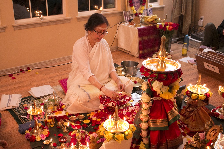 Pujarini arranging puja lamps