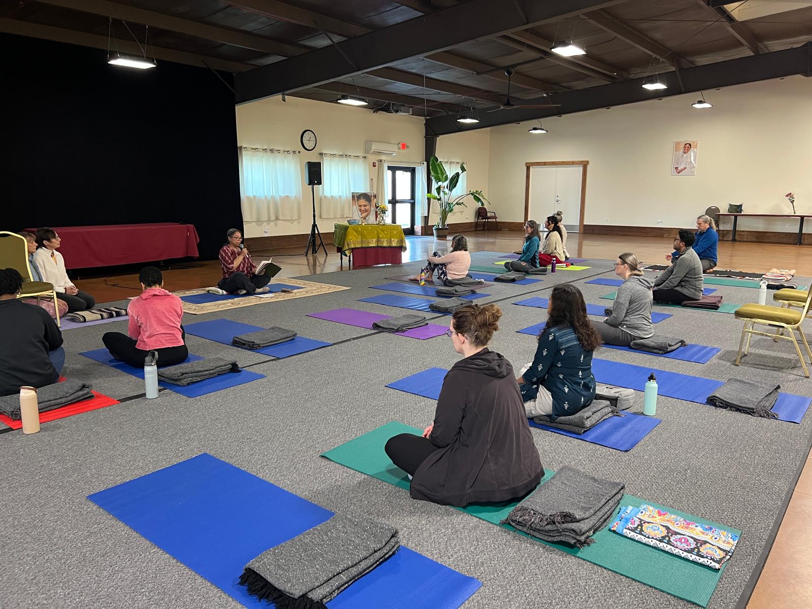 Students on yoga mats with Amrita Yoga instructor at MACC