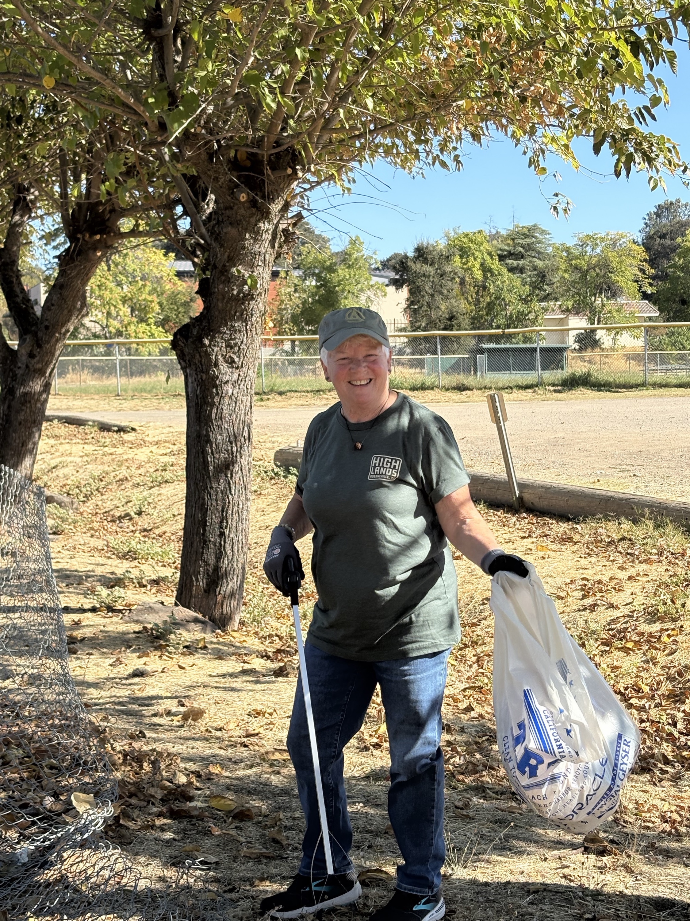 Lake County Satsang volunteer smiling while collecting litter during a community cleanup