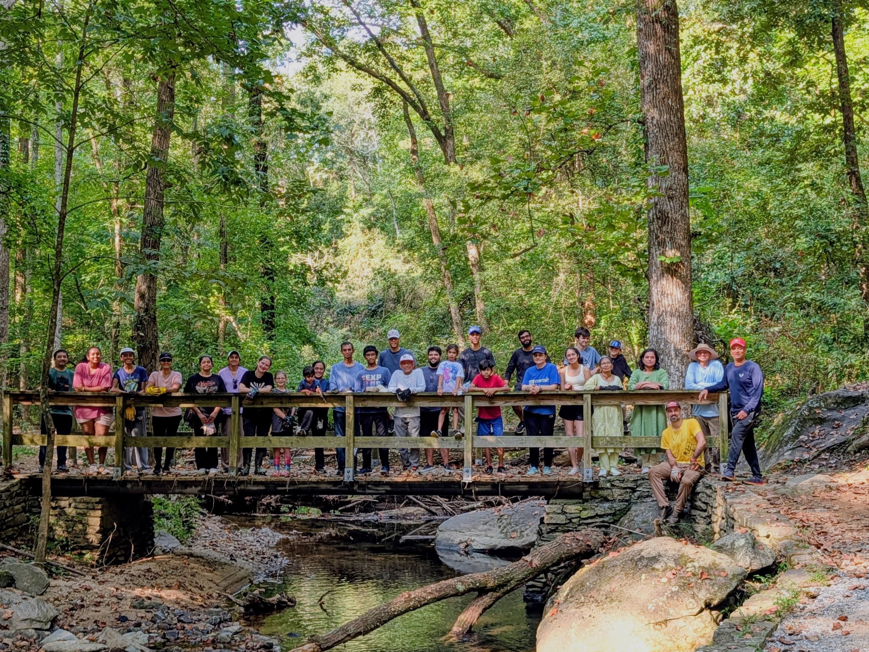 MA Center Atlanta volunteers gathered on a wooden footbridge in Waller Park after the cleanup