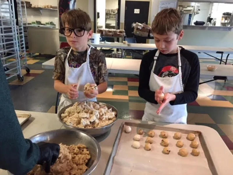 Young volunteers shaping cookies for Mother's Kitchen