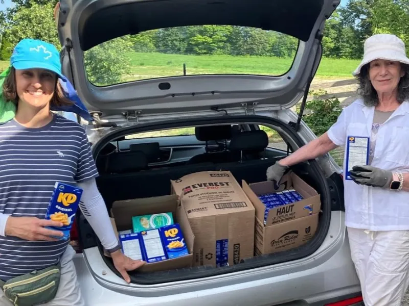 Volunteers Ayana and Mahita with donated Kraft Dinner boxes