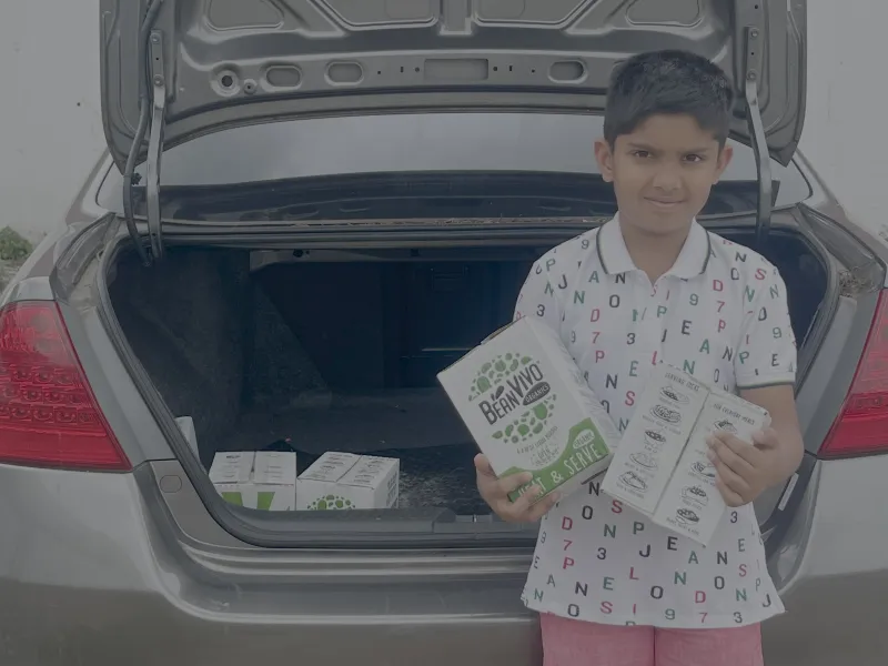 A young volunteer holding packets of donated vegetarian chilli