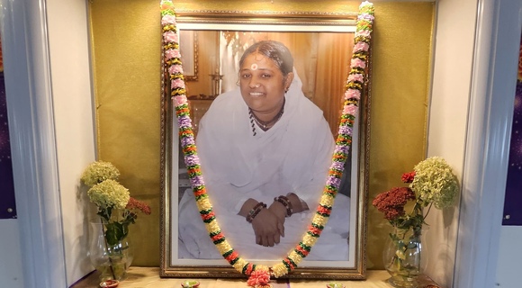 Amma's photo on the altar with garland and fresh flowers