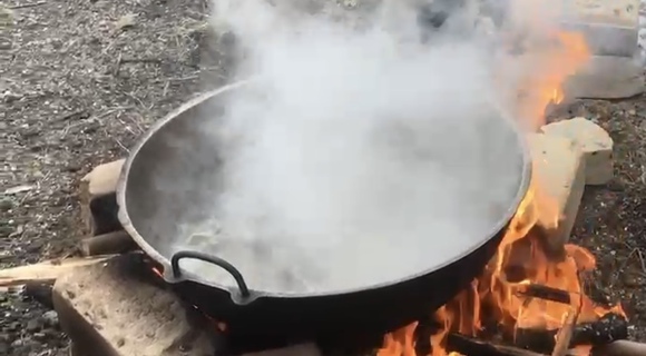 Maple sap boiling in pot over fire