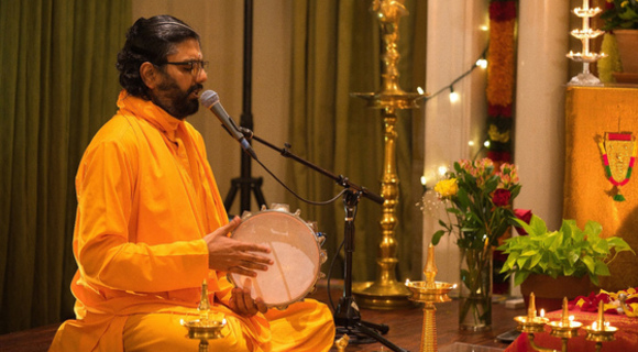 Ramanandamrita Chaitanya singing at a microphone
