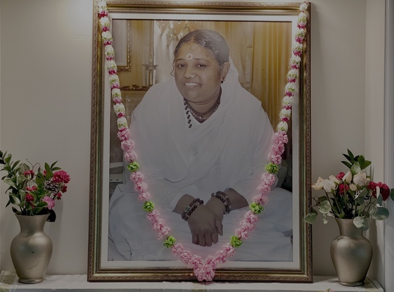 Amma's portrait on altar with garland and fresh flowers