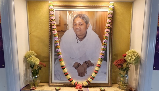 Amma's photo on altar with garland and fresh flowers