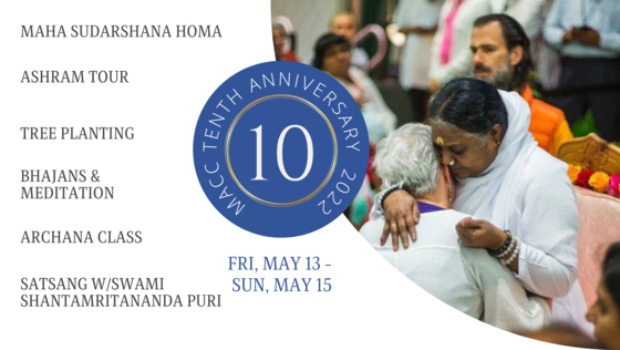 Amma giving darshan at MACC with Swami Shantamritananda in the background