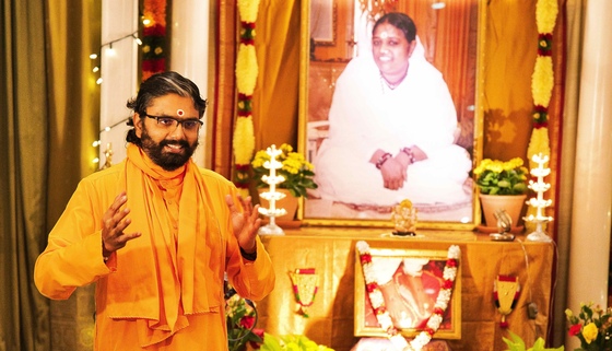 Ramanandamrita Swamiji speaking in front of Amma's photo