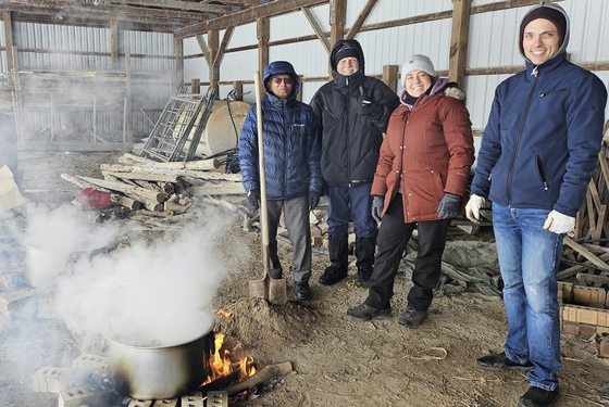 Volunteers boiling maple sap in a shed