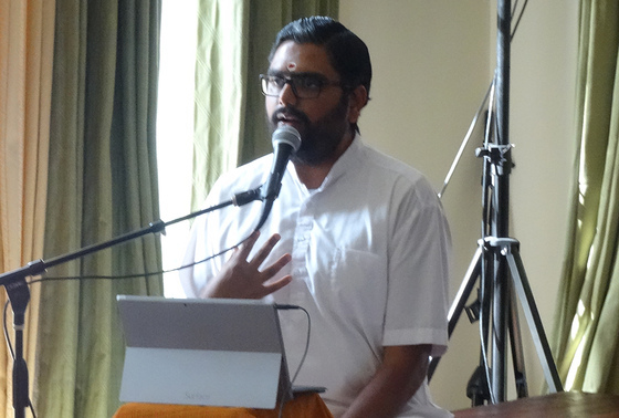 Brahmachari Ramanand speaking at a microphone