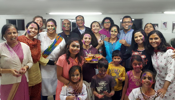 Group photo of smiling people with colours smeared on their faces