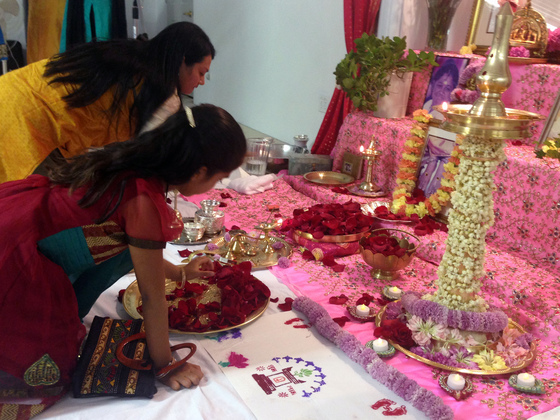 Mother and daughter offering flower petals at the altar