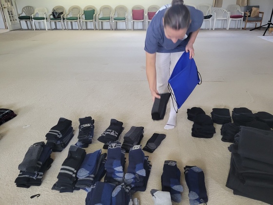 Volunteer packing winter clothing items in homeless care packages