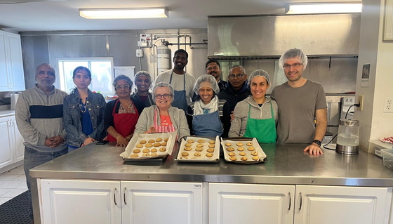 Volunteers with chocolate chip cookies they baked