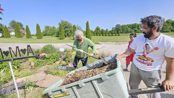 Rose & Arjun spreading wood chips in the flower garden