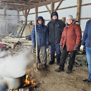 Volunteers boiling maple sap in a shed