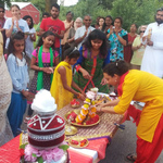 Children and adults arranging murtis on a decorated table