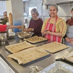 Many volunteers in kitchen at peak of baking