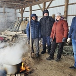 Volunteers boiling maple sap in a shed
