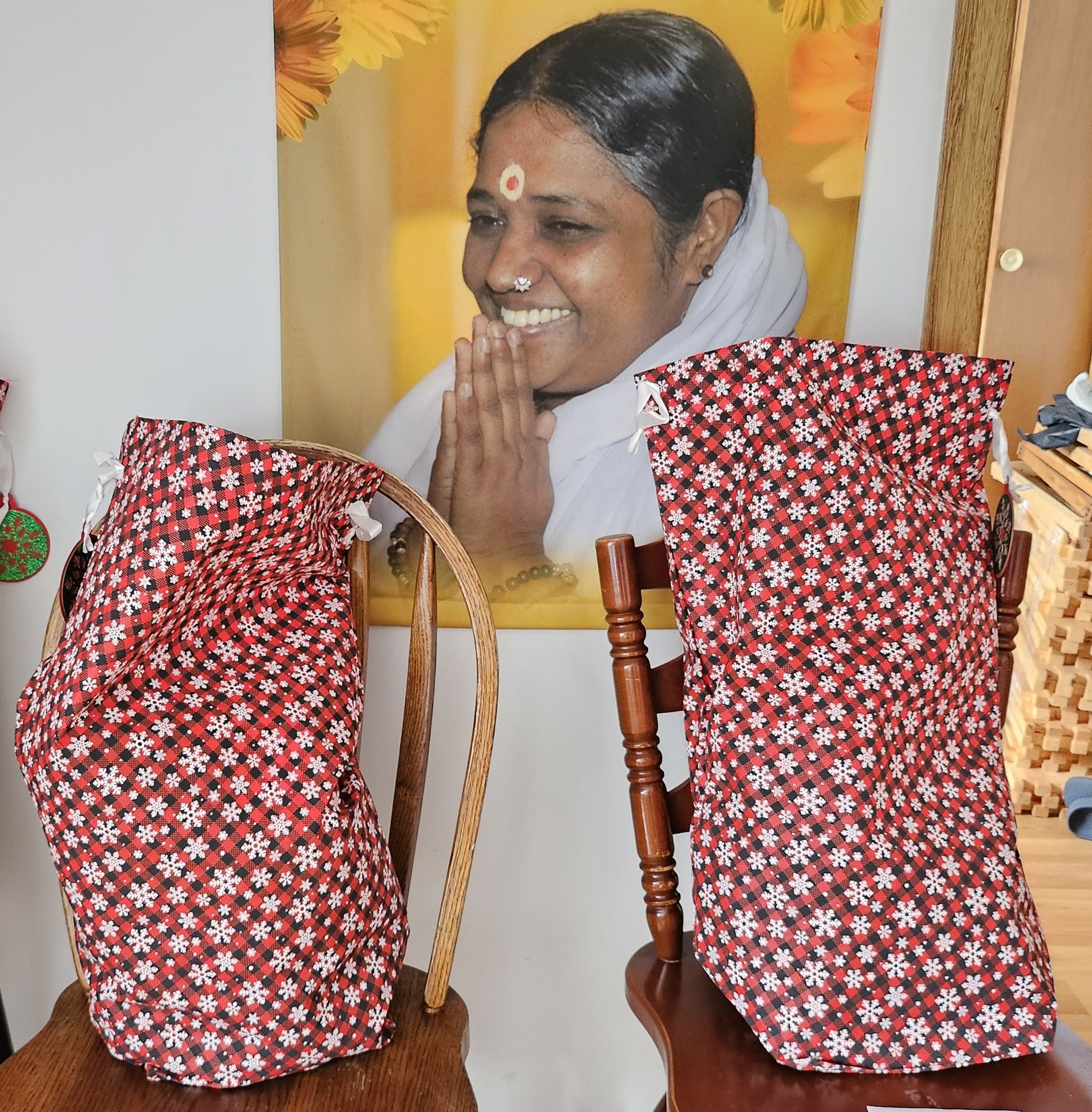 Amma's photo with Santa sacs filled with holiday gifts for the needy