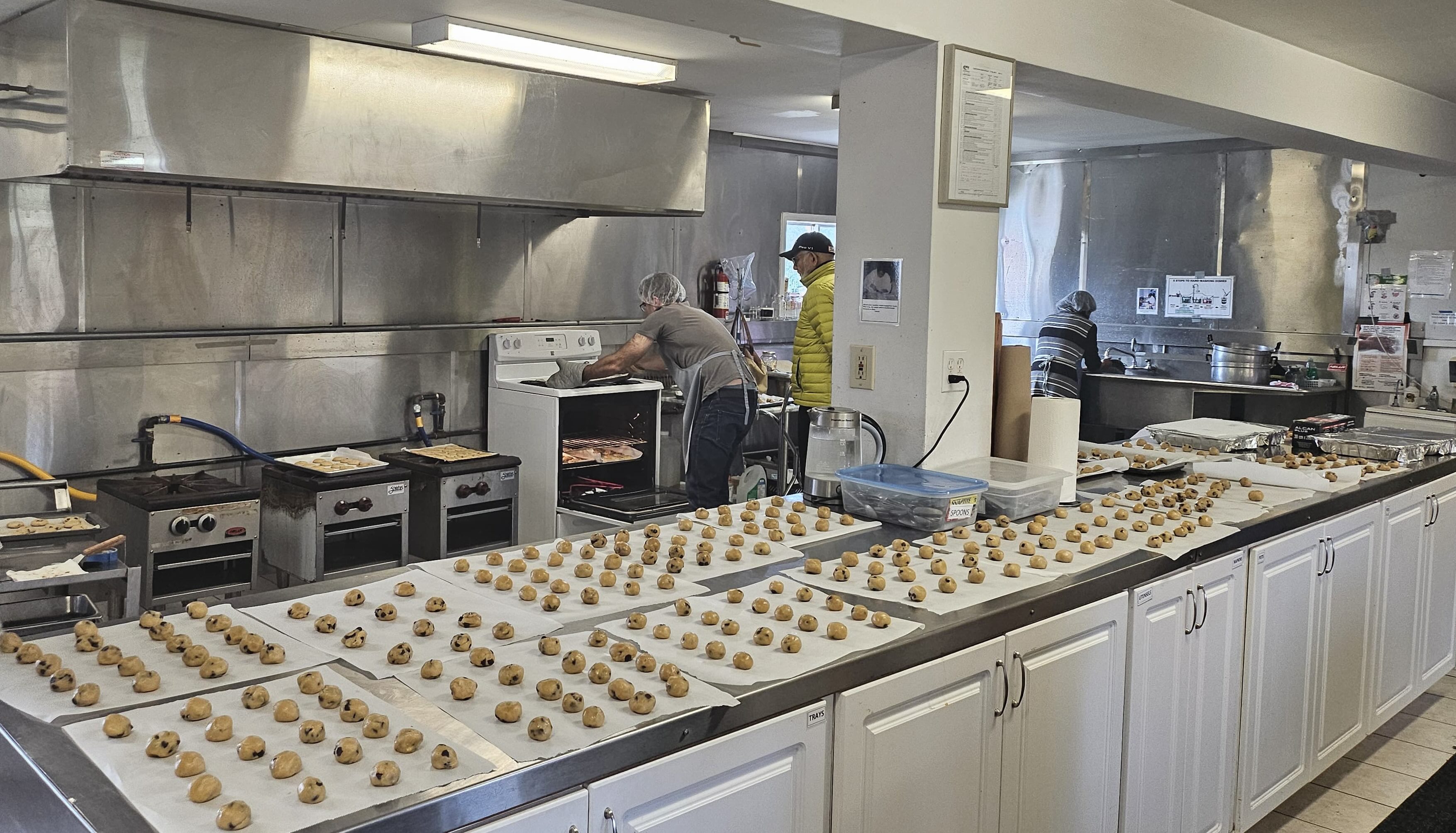 Hundreds of cookies on parchement waiting to be baked
