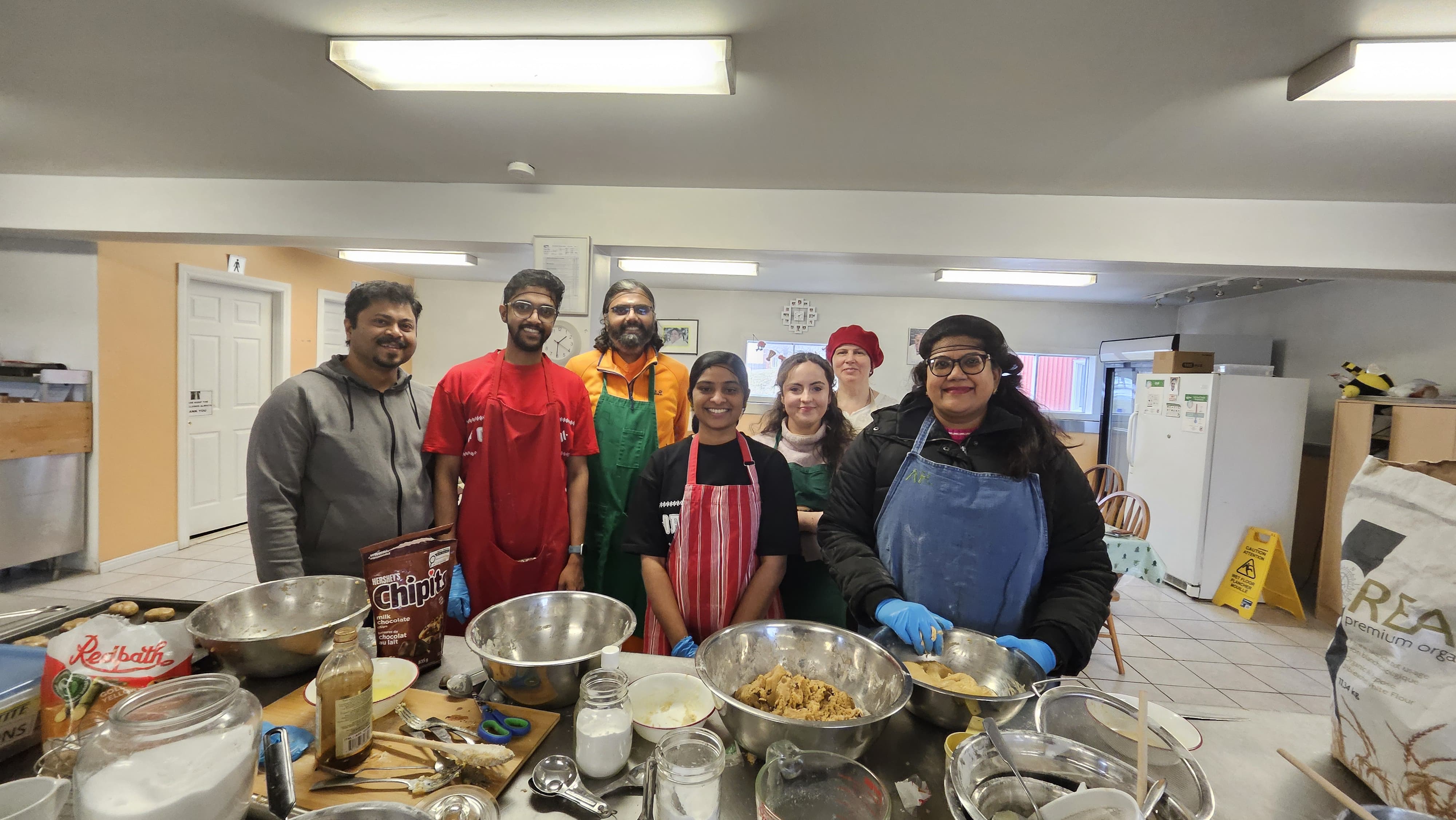 AYUDH Toronto volunteers with Ramanandamrita Swamiji and Vidya ready to bake cookies