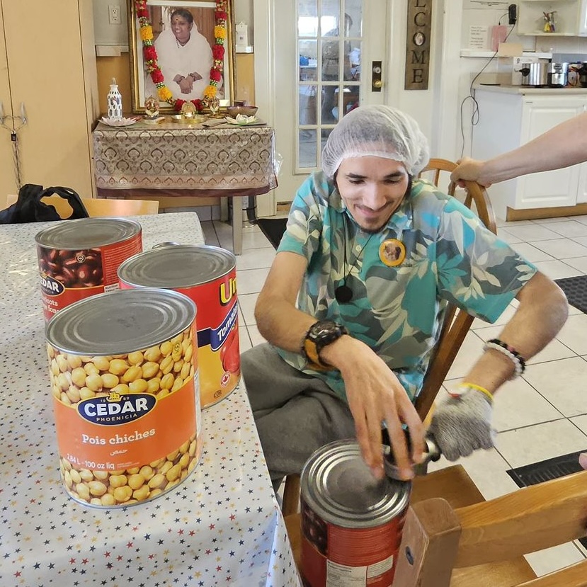 Amma Canada volunteer opening cans of beans & tomatoes
