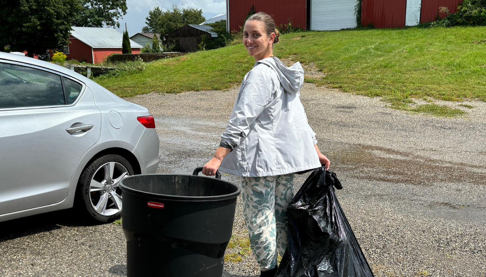 Volunteer taking out the trash from the bee barn