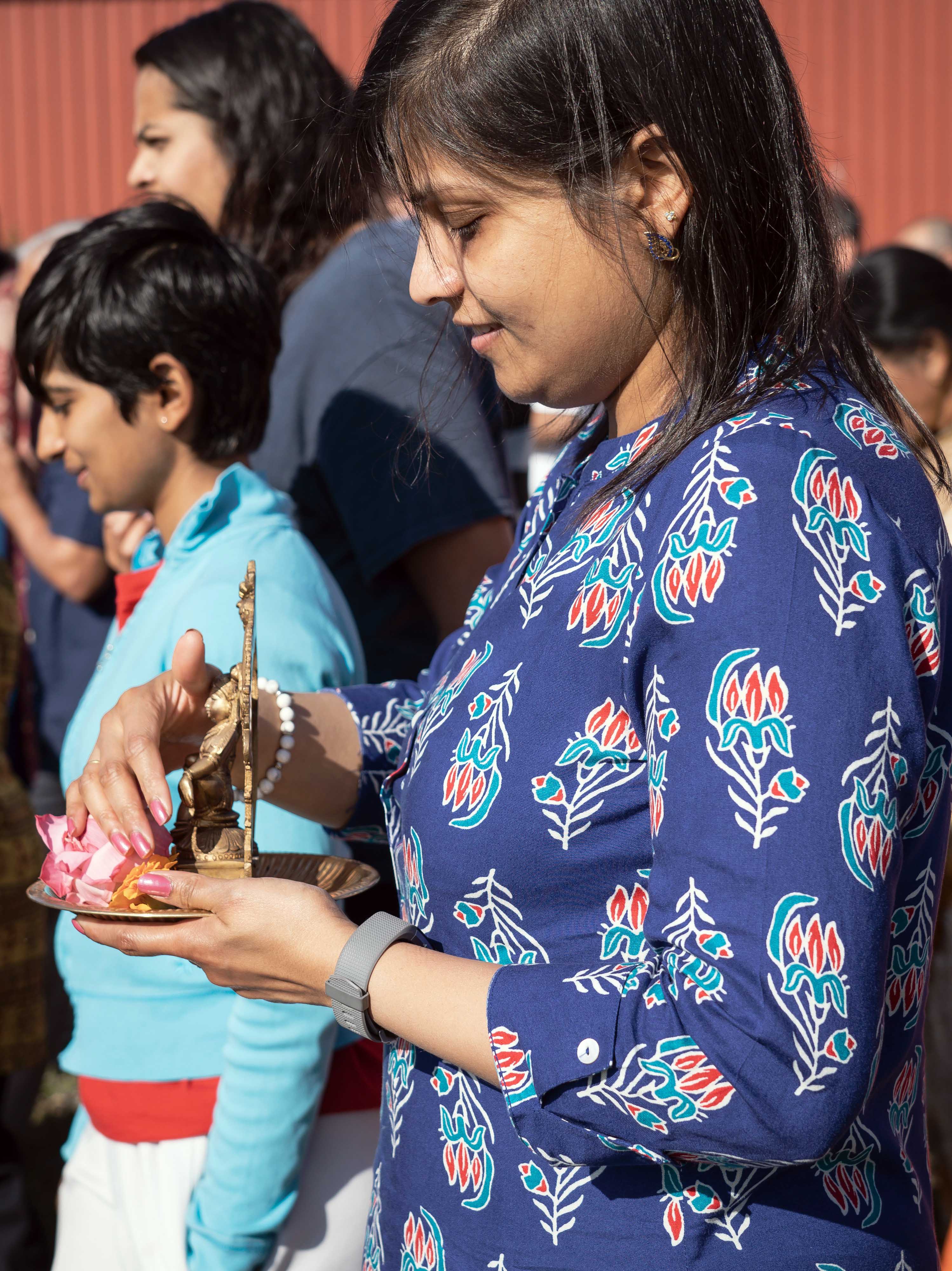 Woman carrying Krishna murti in a procession