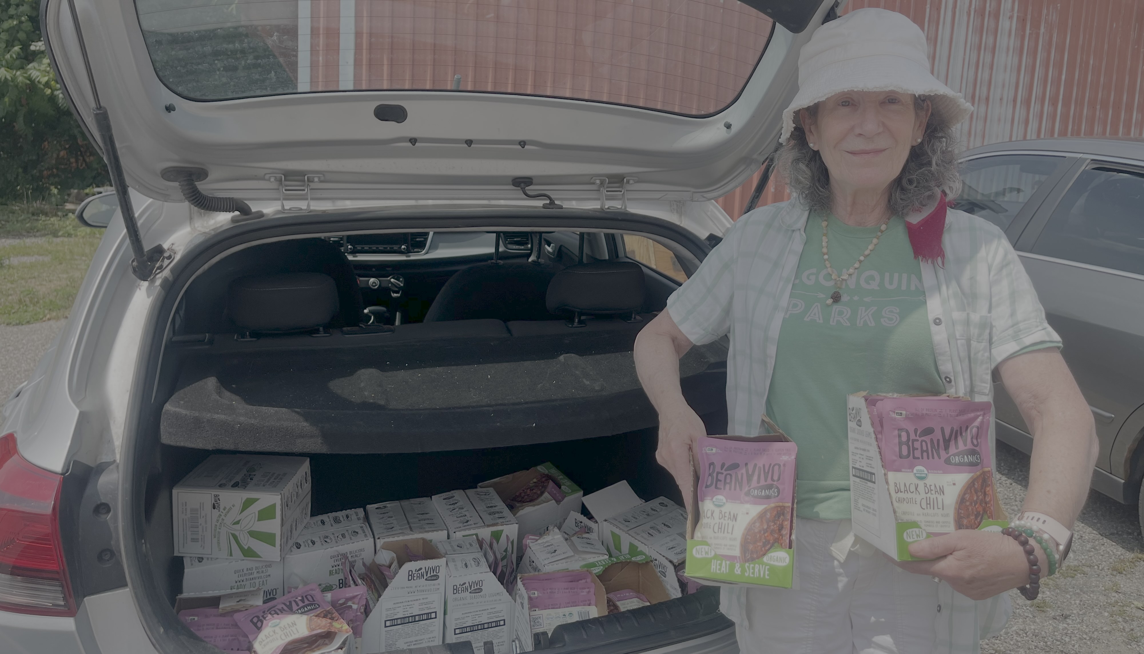 Volunteer with packs of chilli in trunk of car