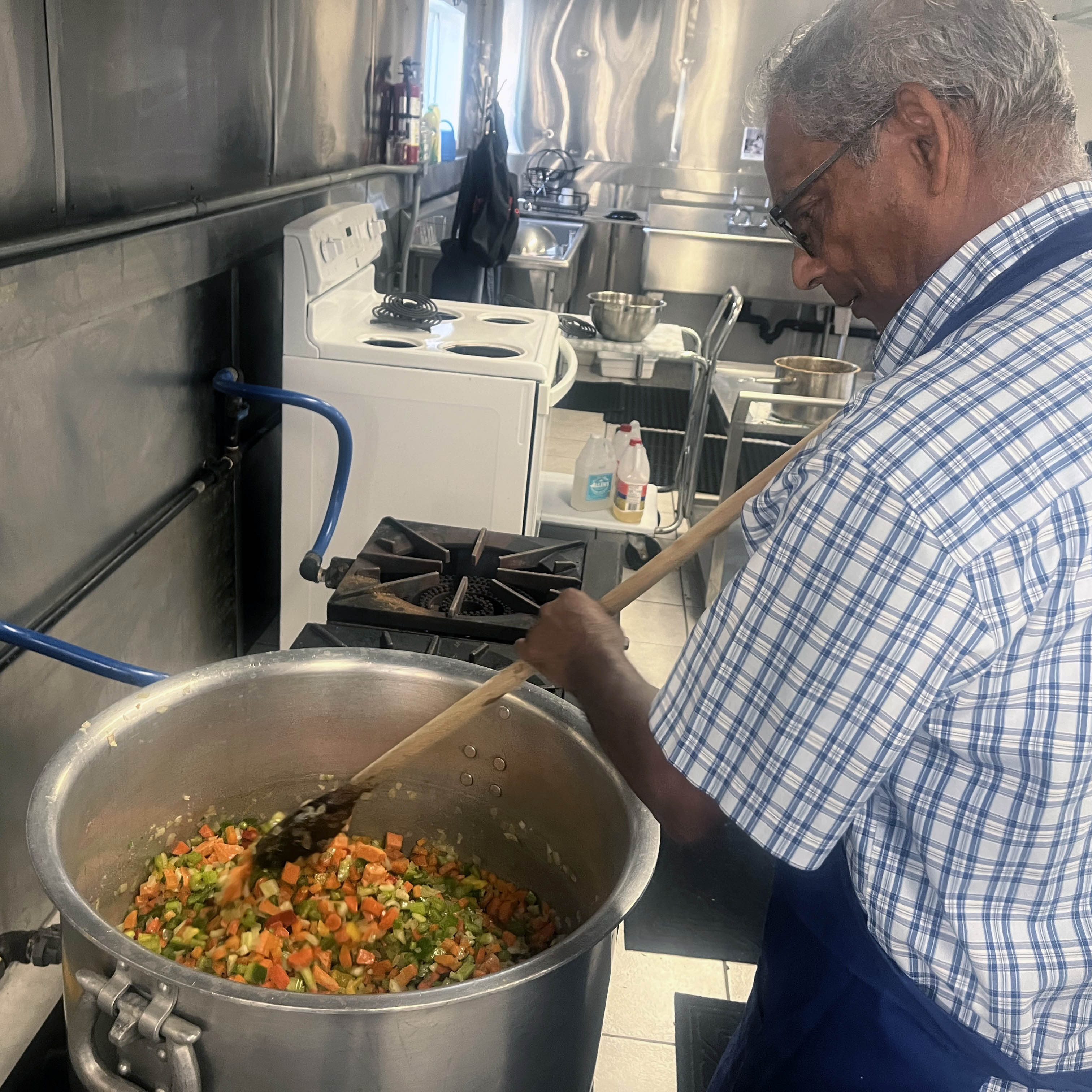 Amma Canada volunteer stirring chilli