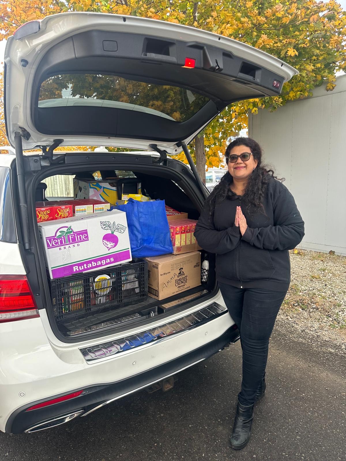 Amma Canada volunteer with non-perishable food in trunk of car 