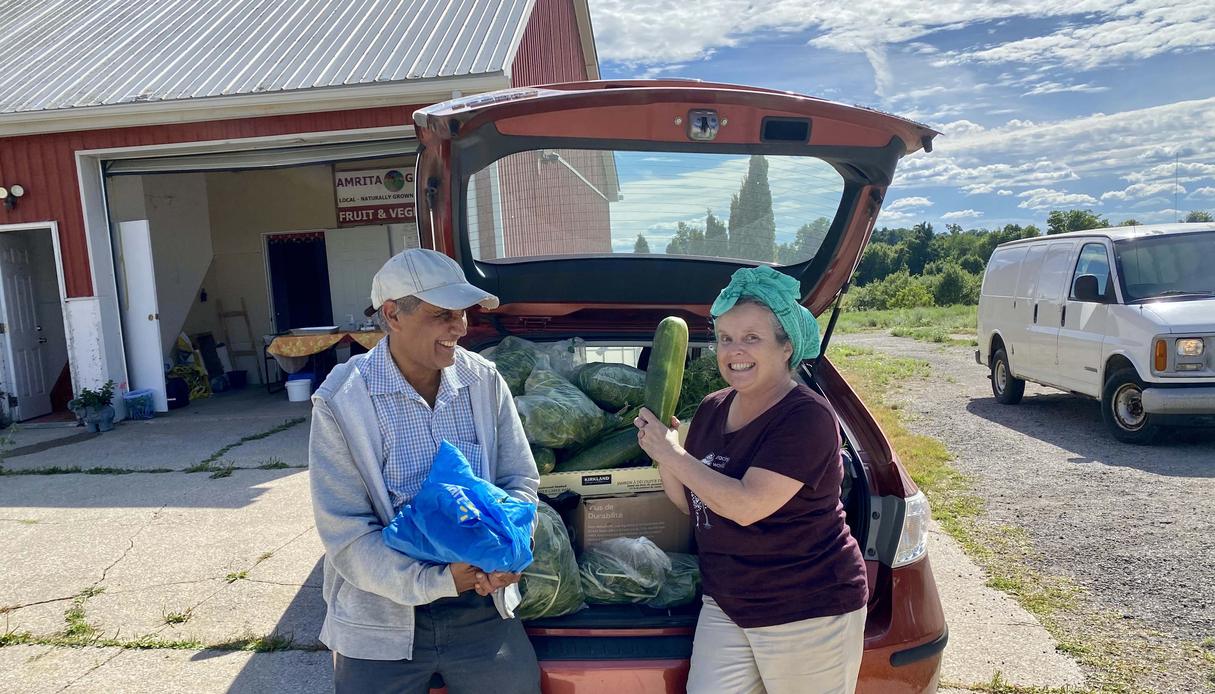 Volunteers loading produce donations into the car to take to the food bank