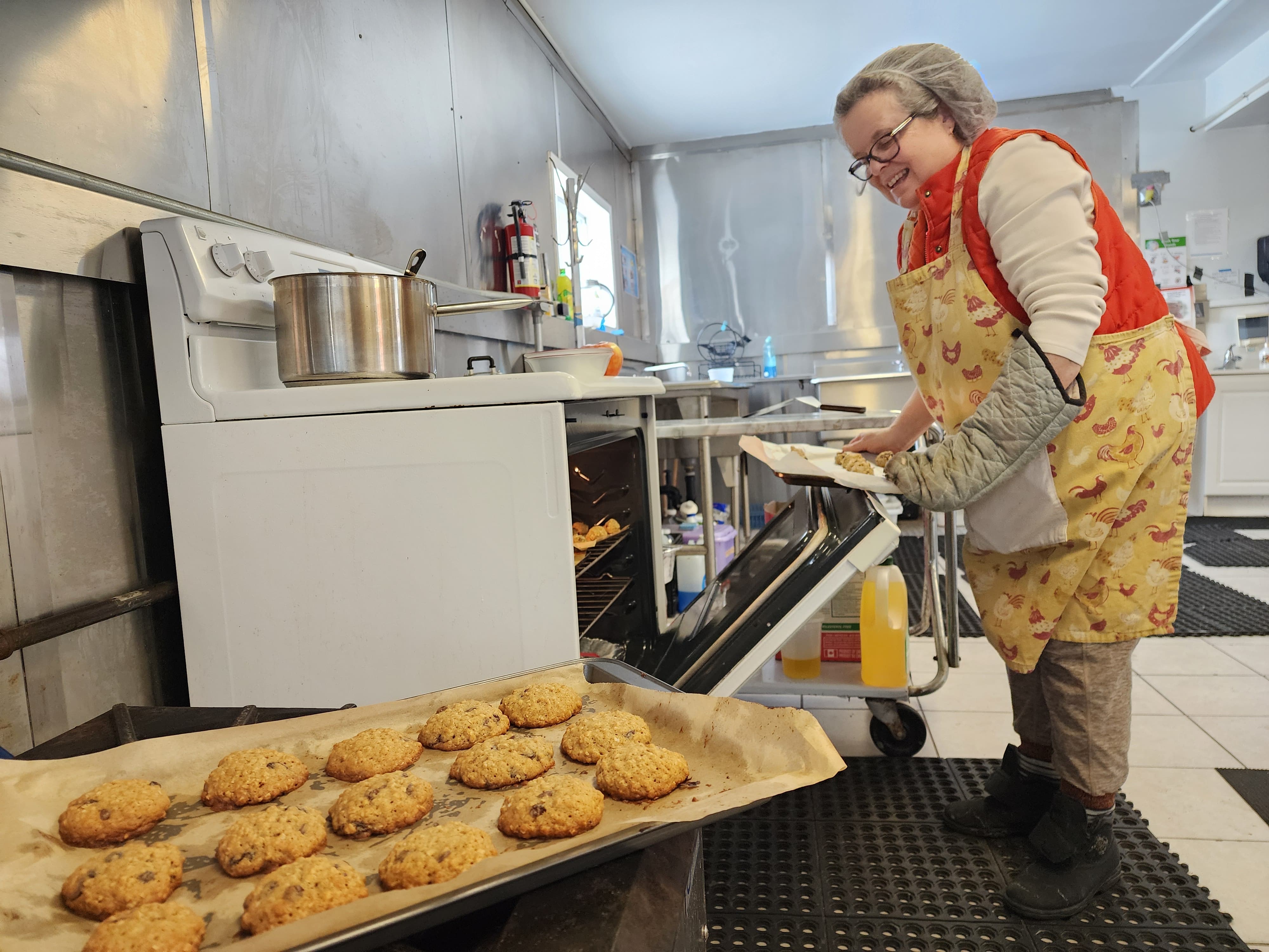 Volunteer taking cookies out of the oven