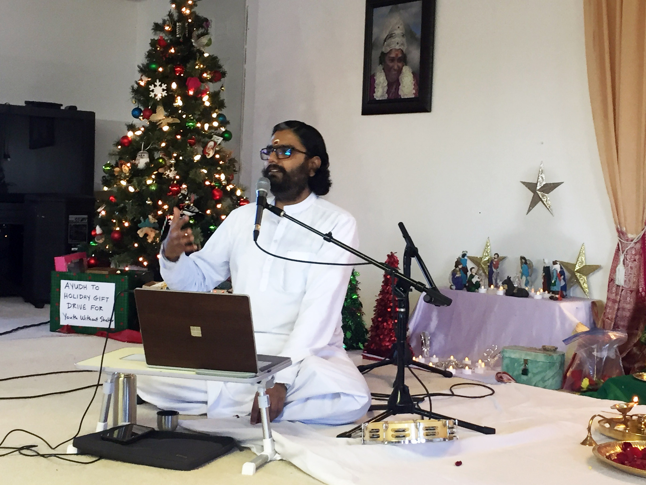 Br Ramanand gesturing and speaking at the mic