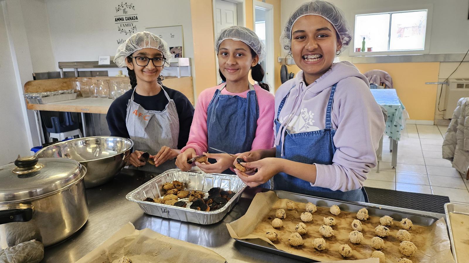 Three young volunteers handling cookies