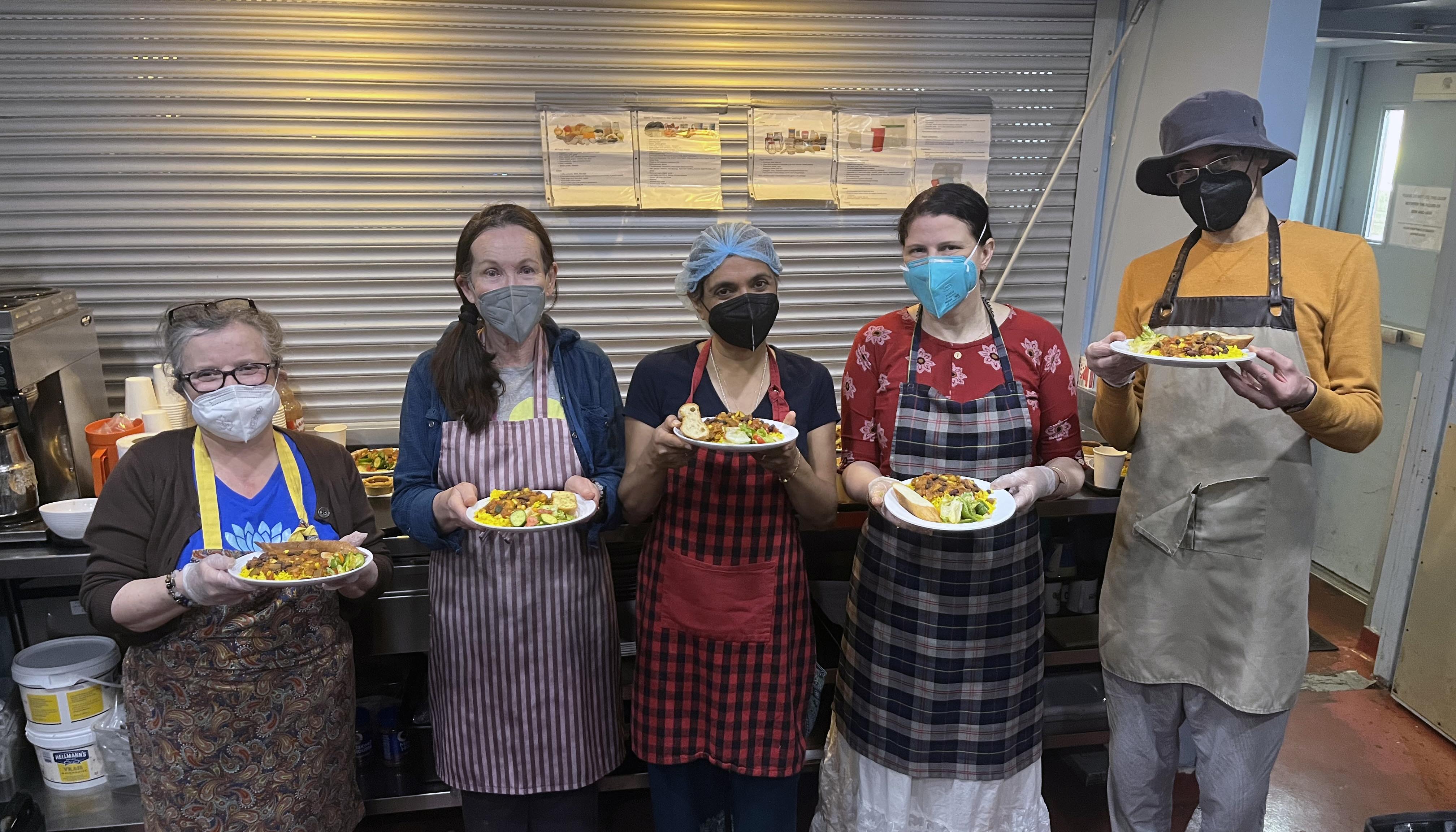 Volunteers with plates of chilli at St Felix August Avenue kitchen