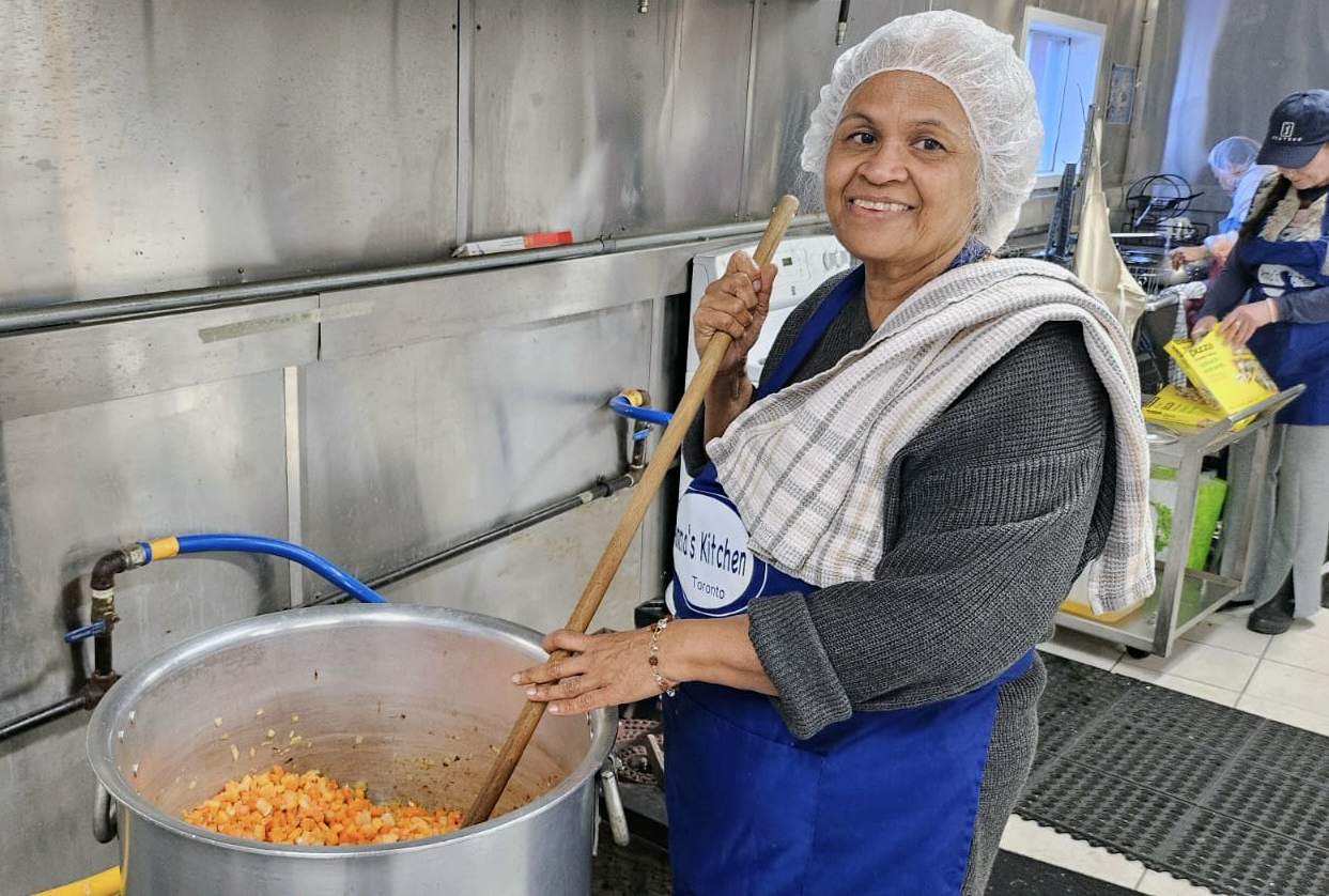 Volunteers stirring pot of chilli