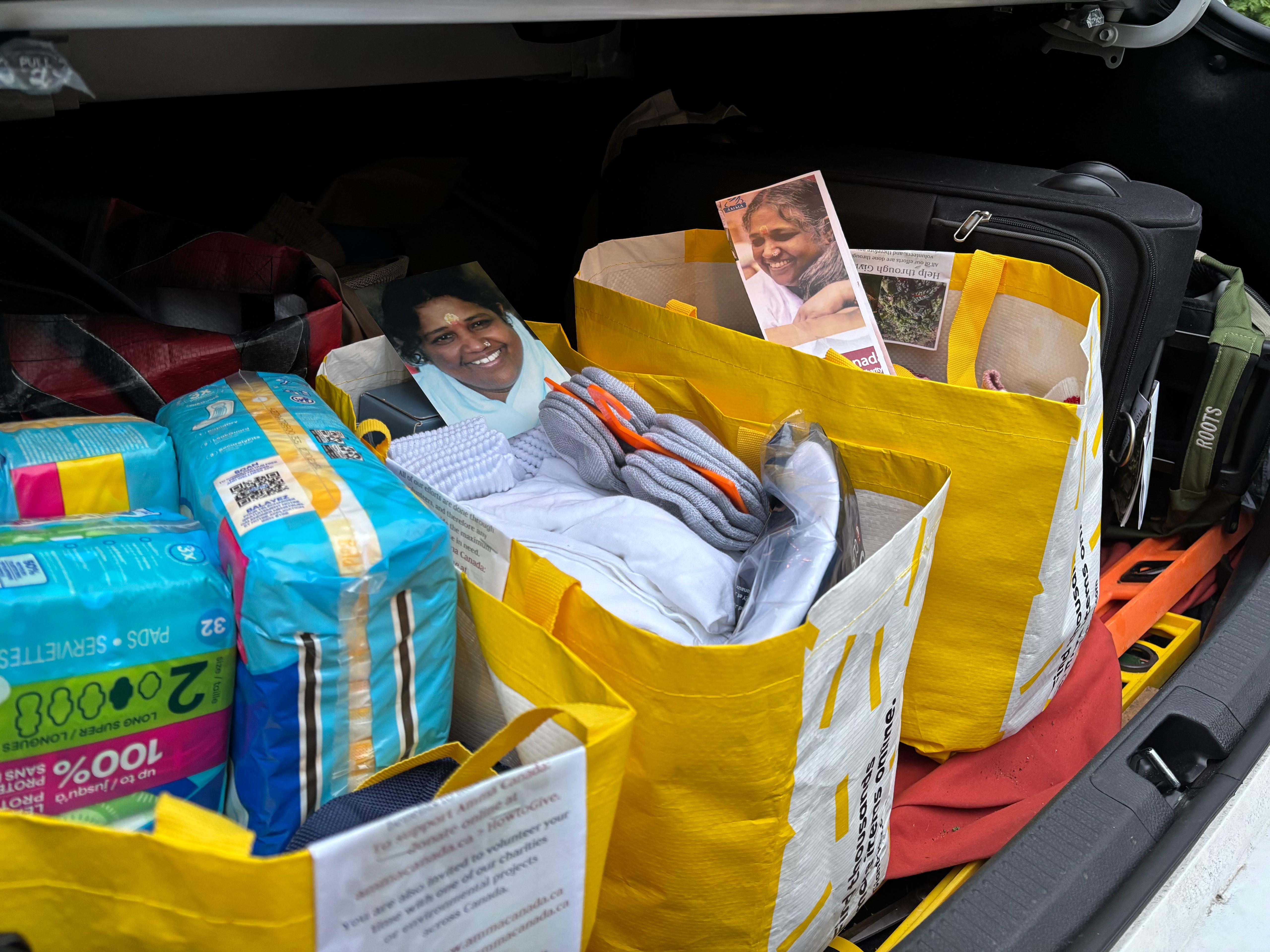 Donated socks, underwear, menstrual pads and suitcases in trunk of car