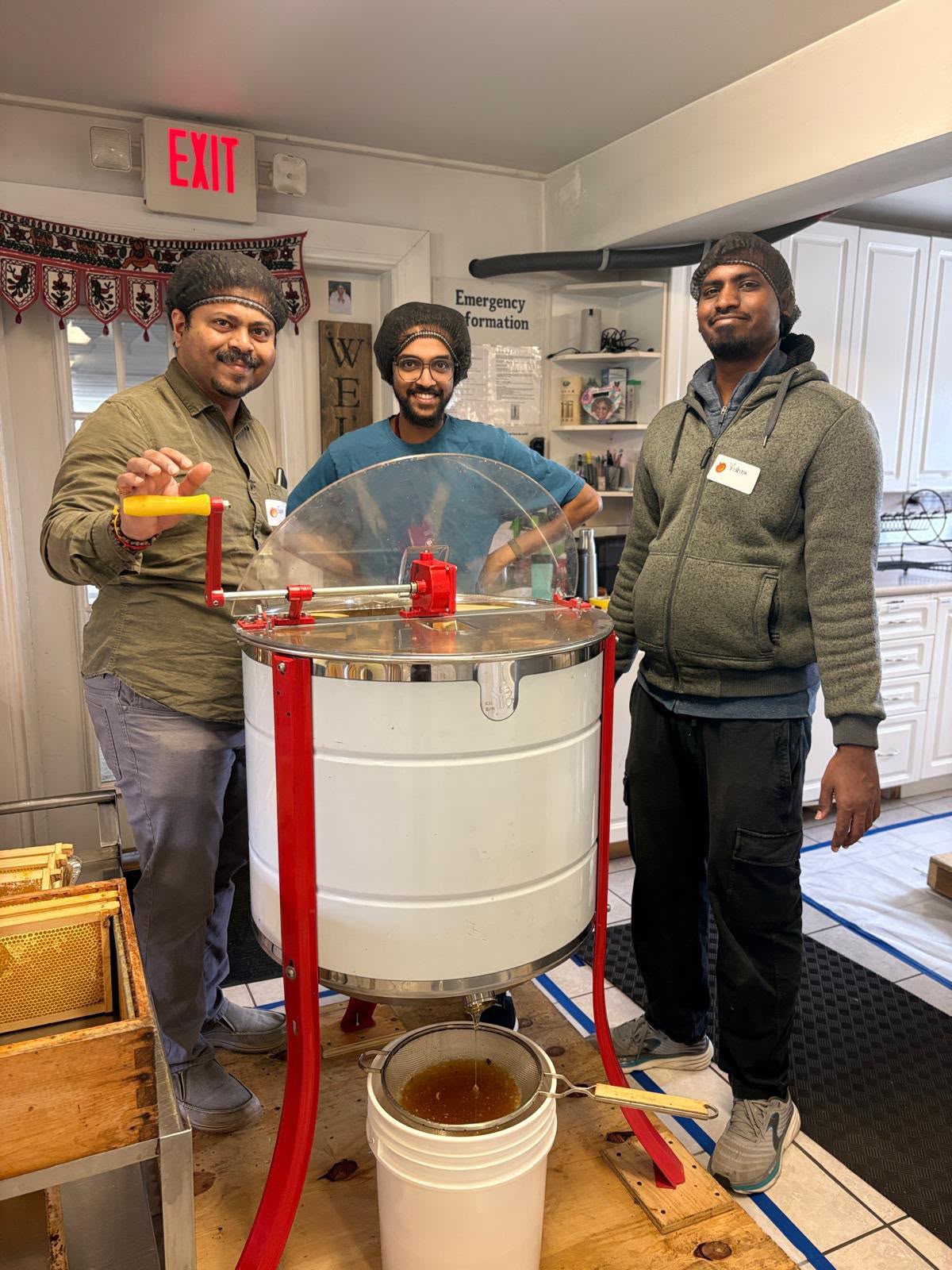 Volunteers operating honey extractor